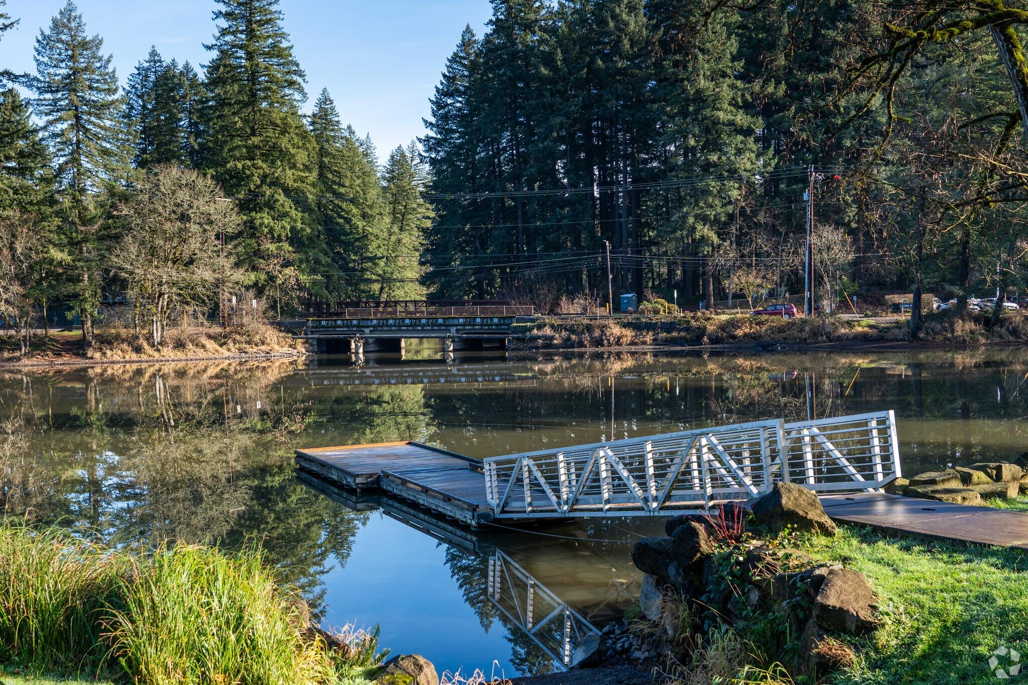 Floating dock and footbridge on a Pacific Northwest lake with fir forest reflected in still water