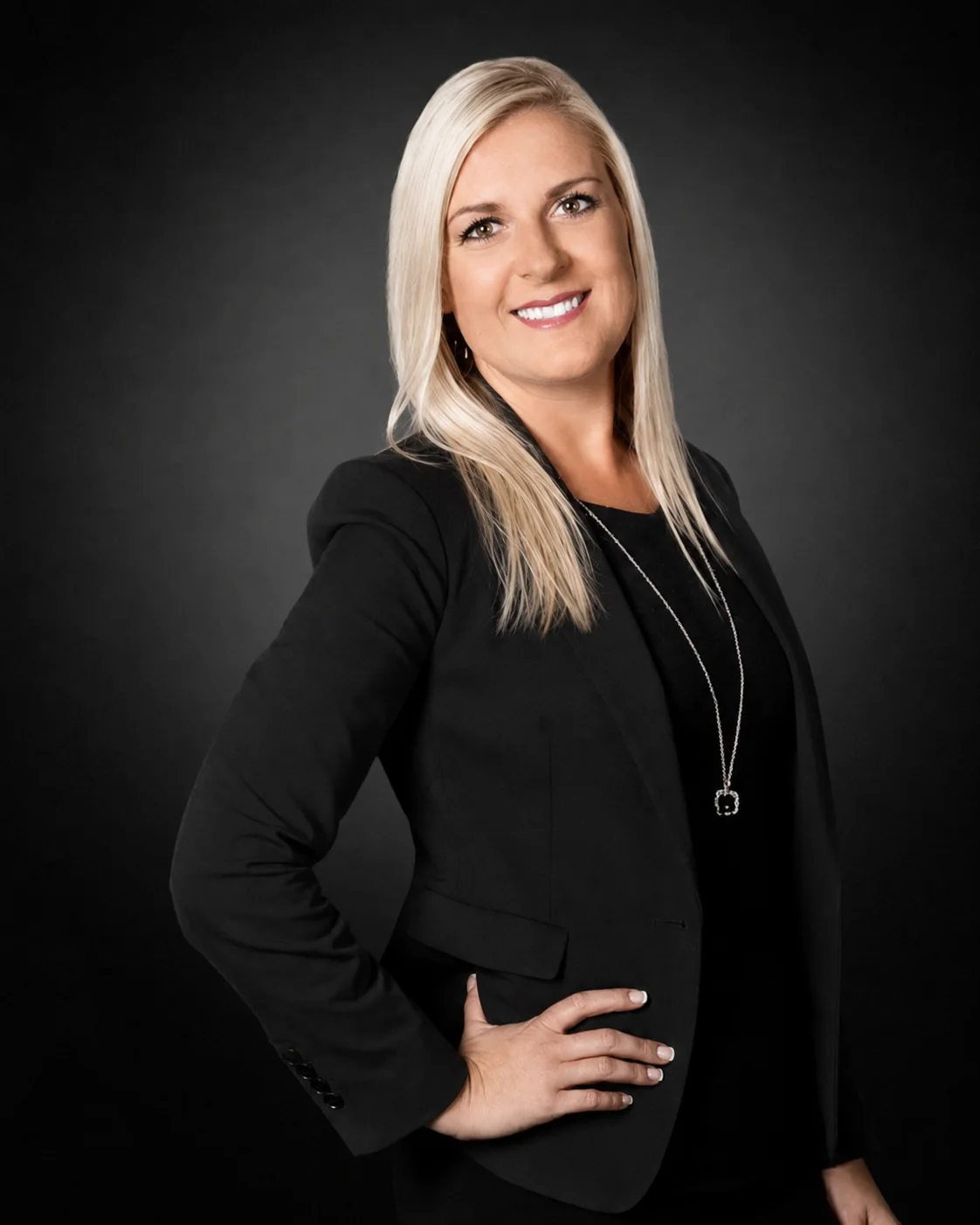 Oksana Berezhnoy in a black blazer against a dark studio background