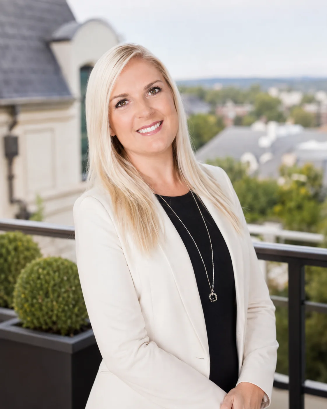 Oksana Berezhnoy in a white blazer on a residential terrace